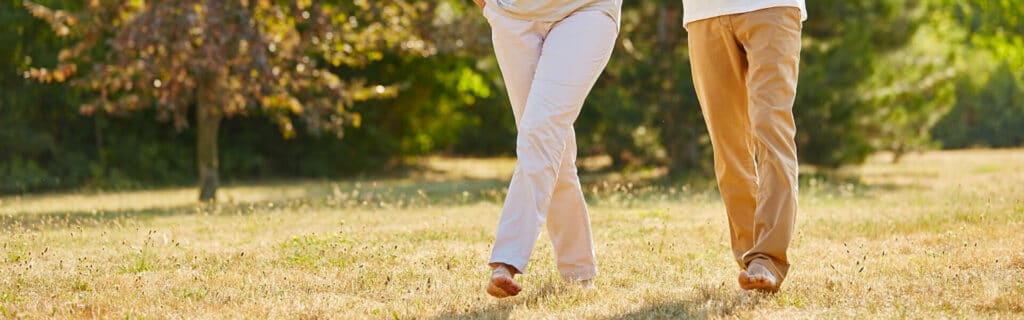 male and female legs walking barefoot on grass