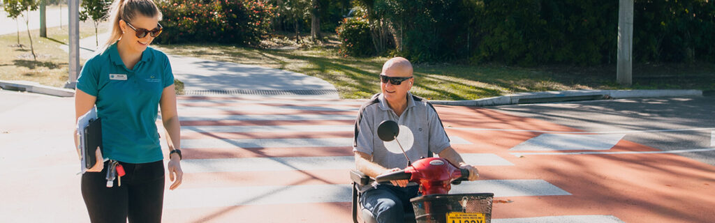 Occupational therapy session with occupational therapist walking next to client trialing a mobility scooter