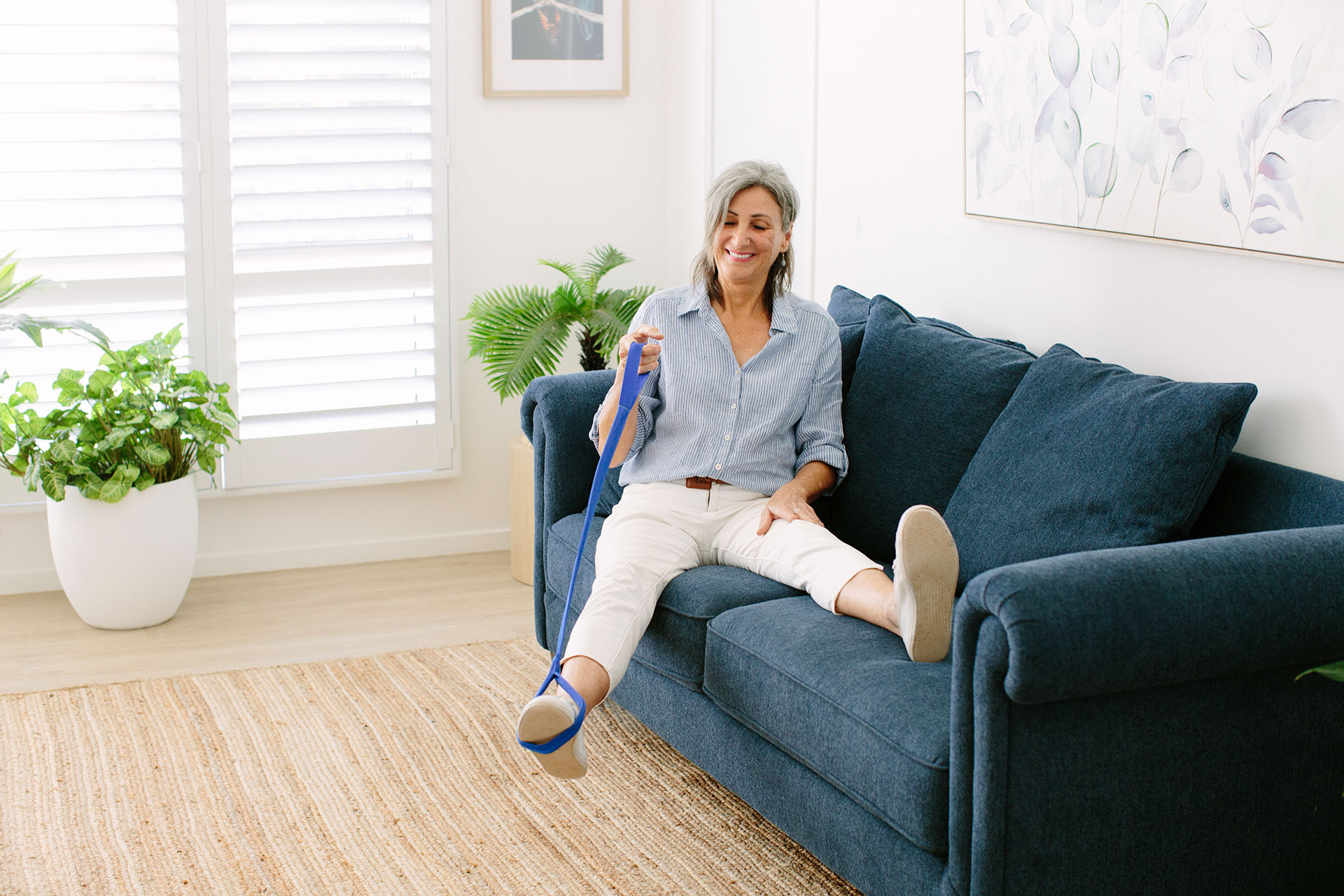 Woman doing physiotherapy exercises on the couch in her home