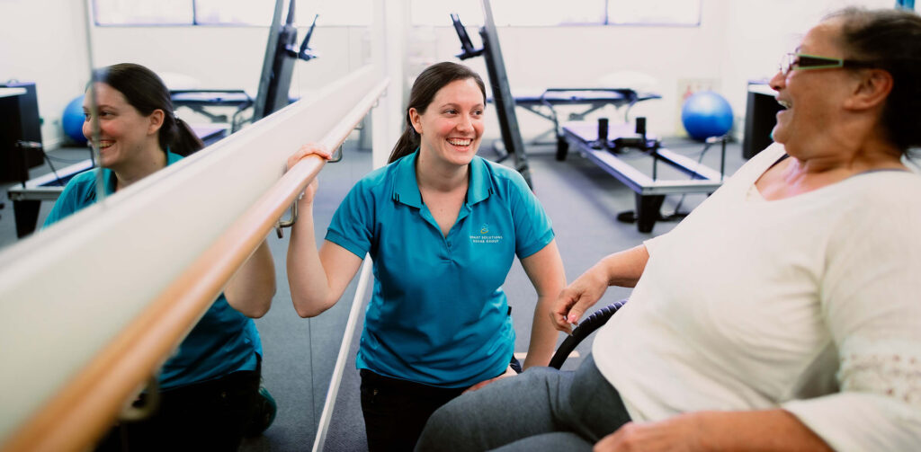 Exercise physiologist helping a participant through clinical exercise interventions
